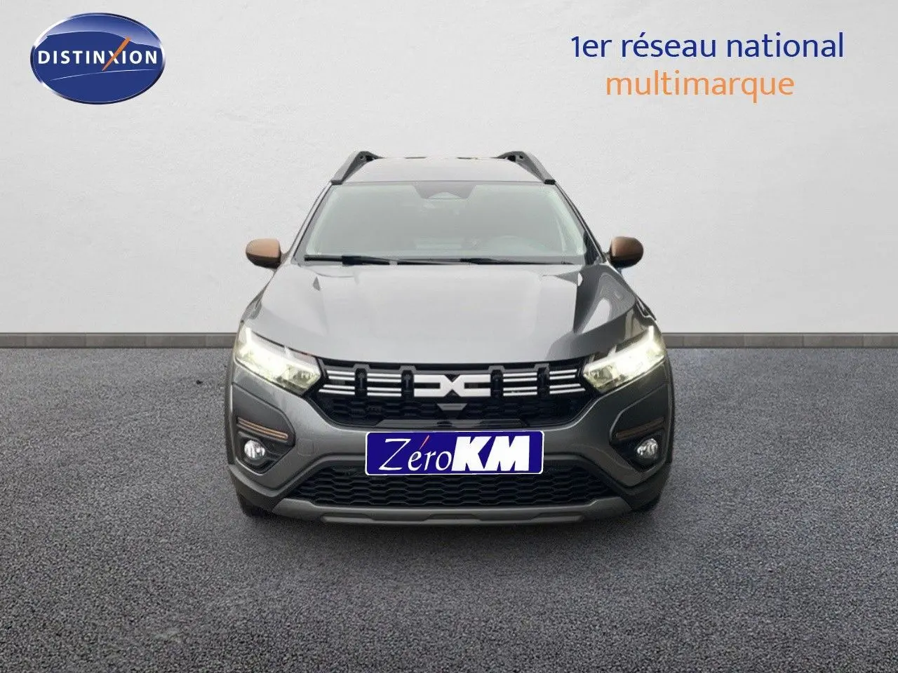 Vue avant d'un Dacia Jogger gris schiste métal 2026 avec phares allumés et calandre noire distinctive.