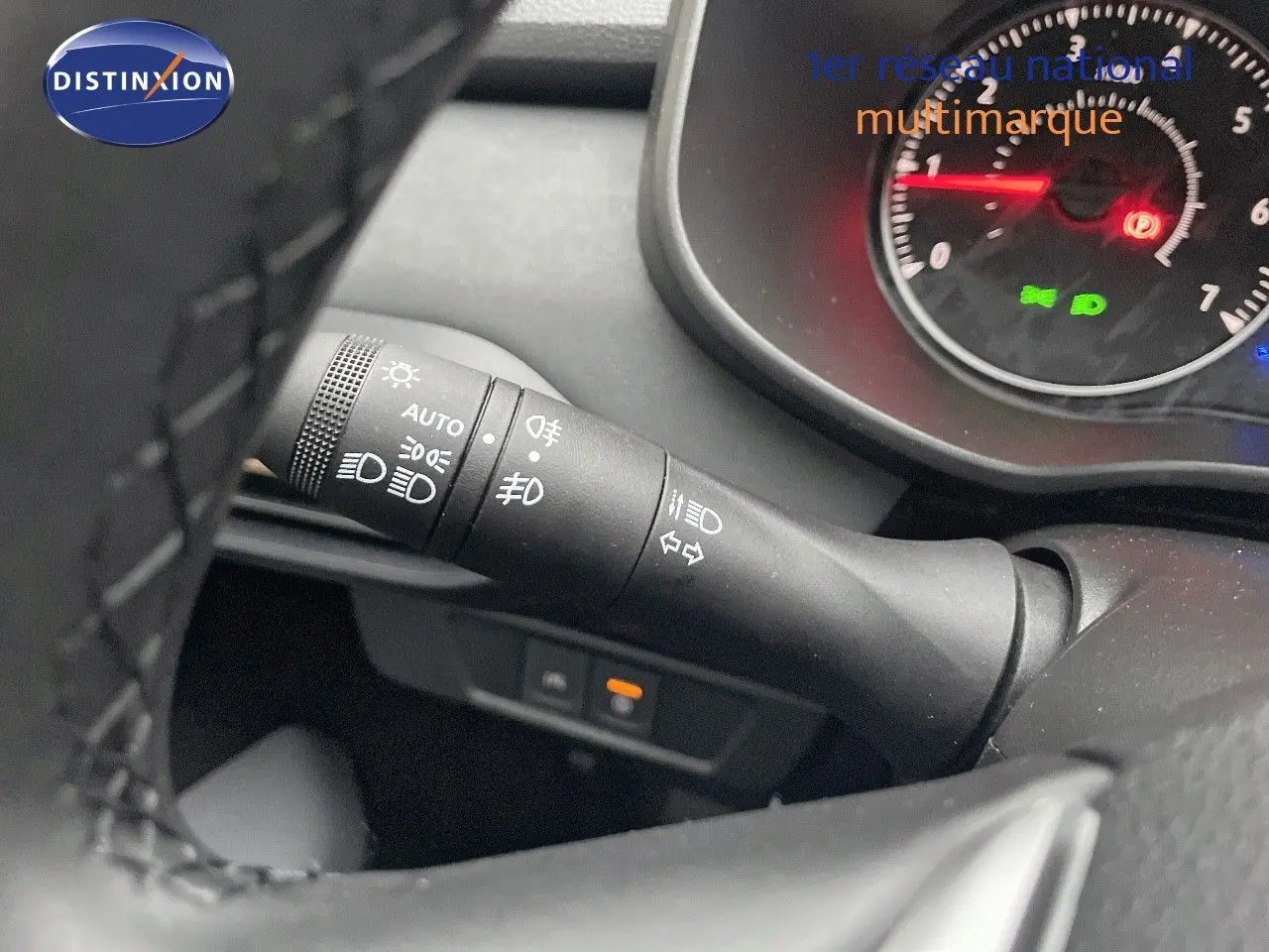 Gros plan sur la manette des phares et clignotants du tableau de bord d'une Dacia Jogger gris schiste métal.