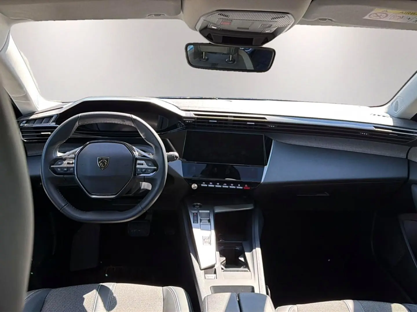 Vue frontale de l’habitacle noir du Peugeot 408 Hybrid 145 allure 2025, avec volant multifonction et écran tactile.