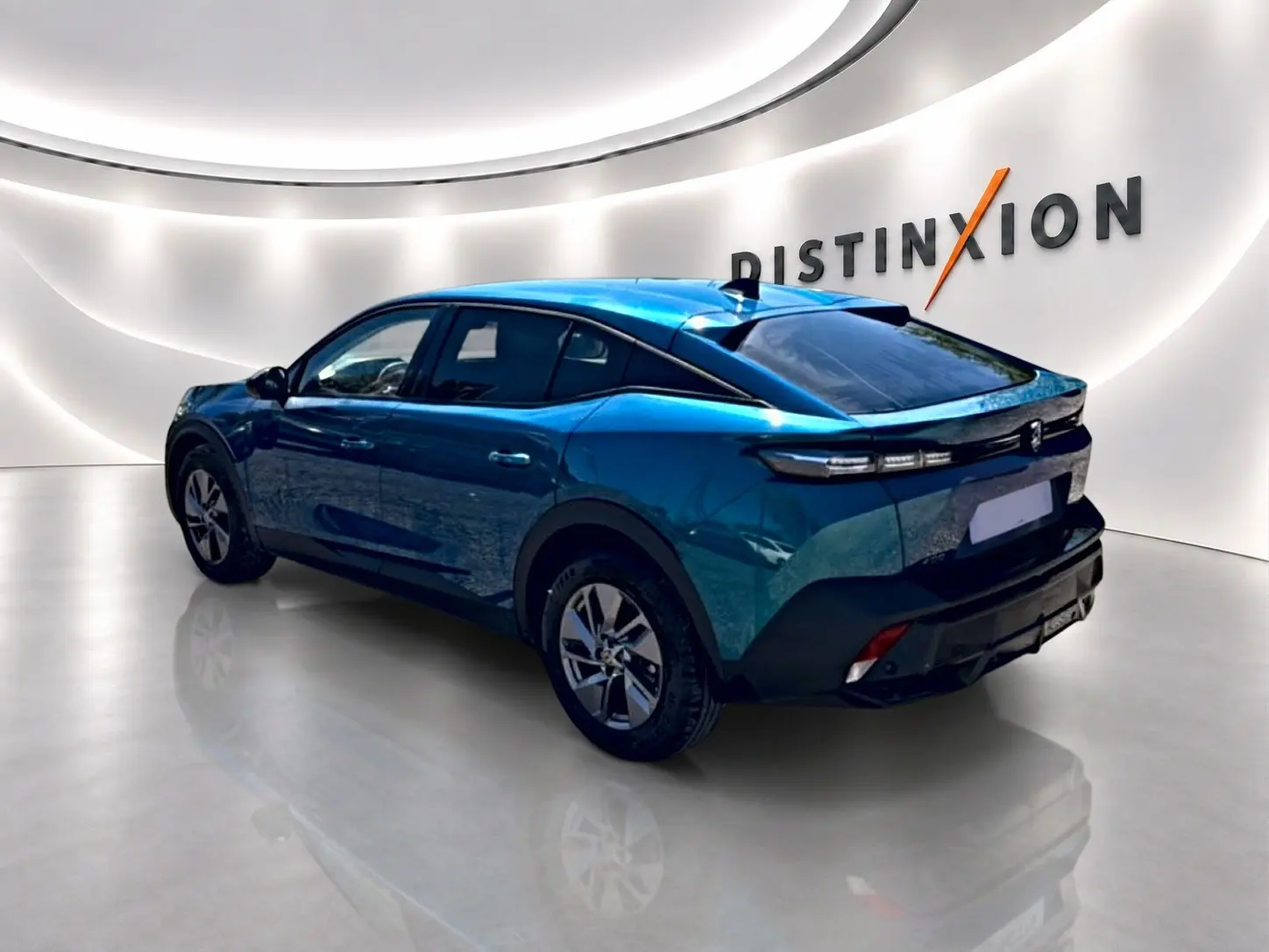 Vue 3/4 arrière droite d'une Peugeot 408 Hybrid 145 allure e-dcs6 bleu dans un showroom lumineux avec logo Distinxion.