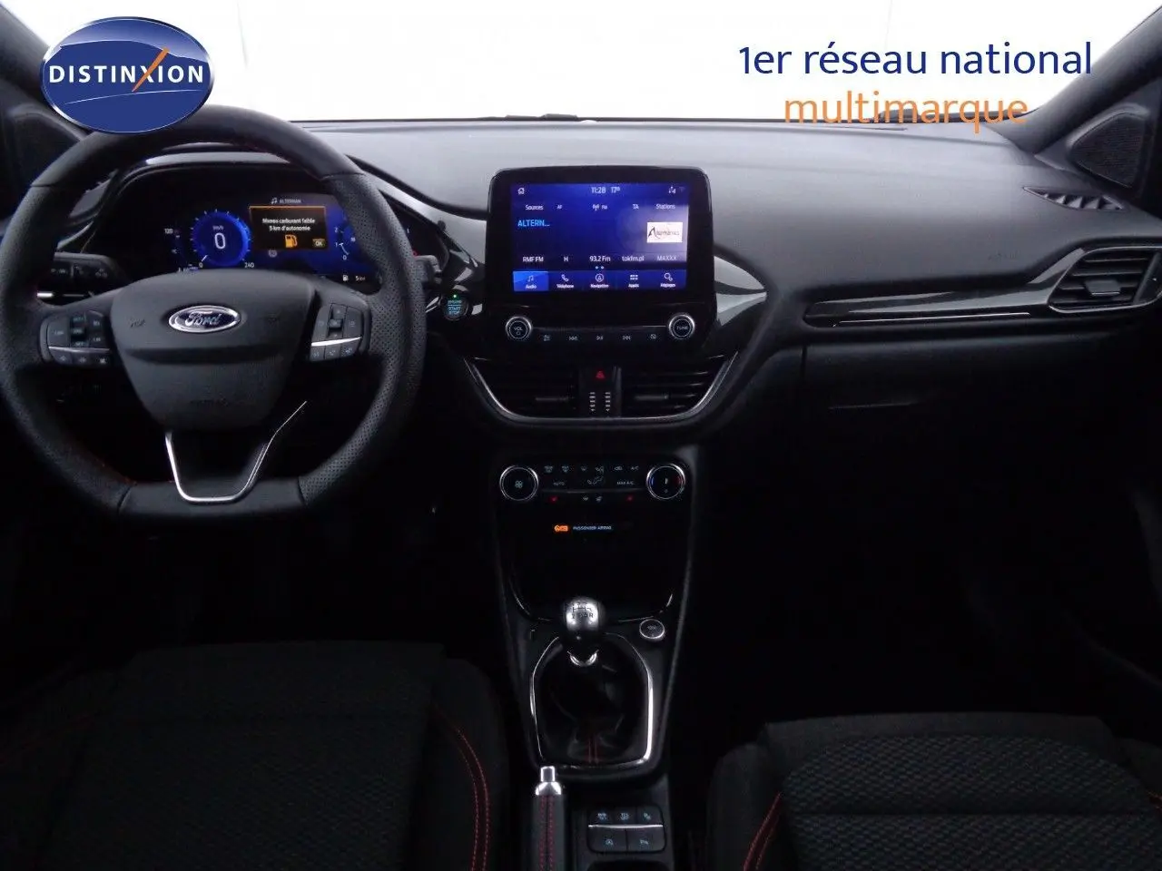 Vue intérieure du tableau de bord et volant d'une Ford Puma gris Solar Metal avec boîte manuelle, affichage numérique et écran tactile central.