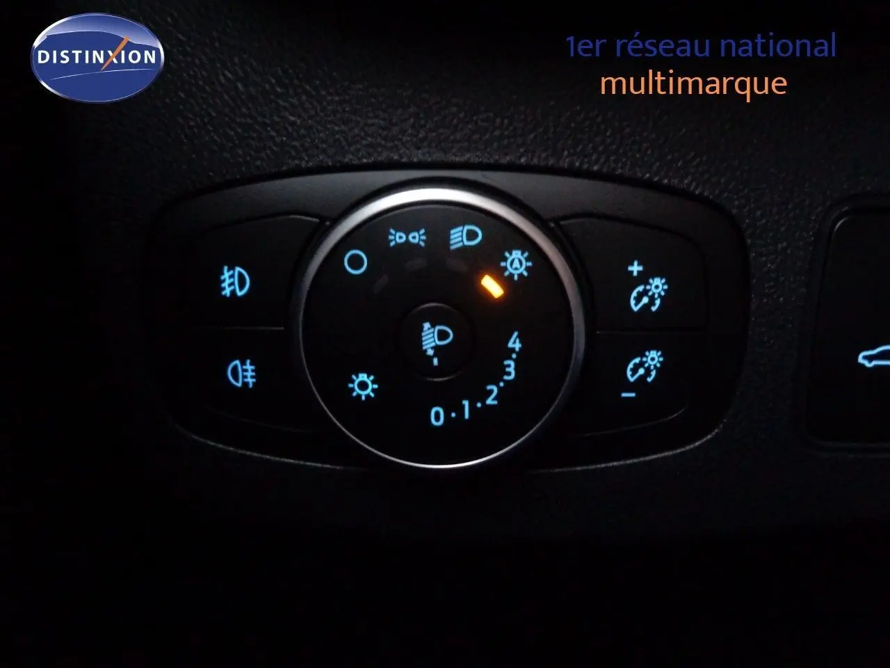 Gros plan sur le bouton de réglage des phares du Ford Puma gris Solar Metal, avec éclairage bleu et orange.