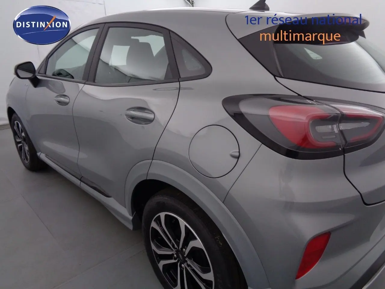 Vue 3/4 arrière côté gauche d'un Ford Puma gris Solar Metal avec feux arrière LED et jantes alliage noires.