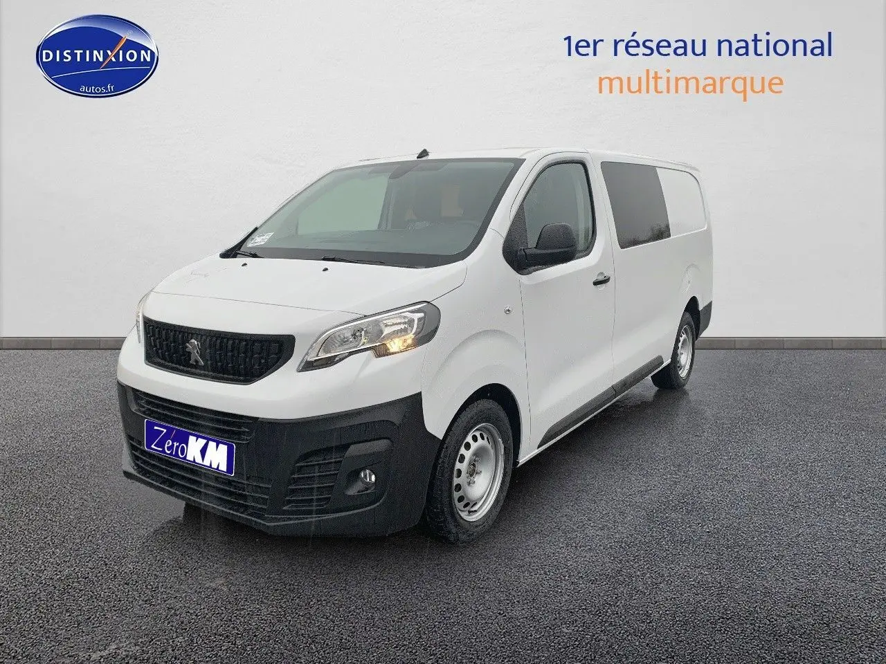 Peugeot Expert Long blanc en 3/4 avant droit avec calandre noire et pare-chocs noir mat sur sol gris.