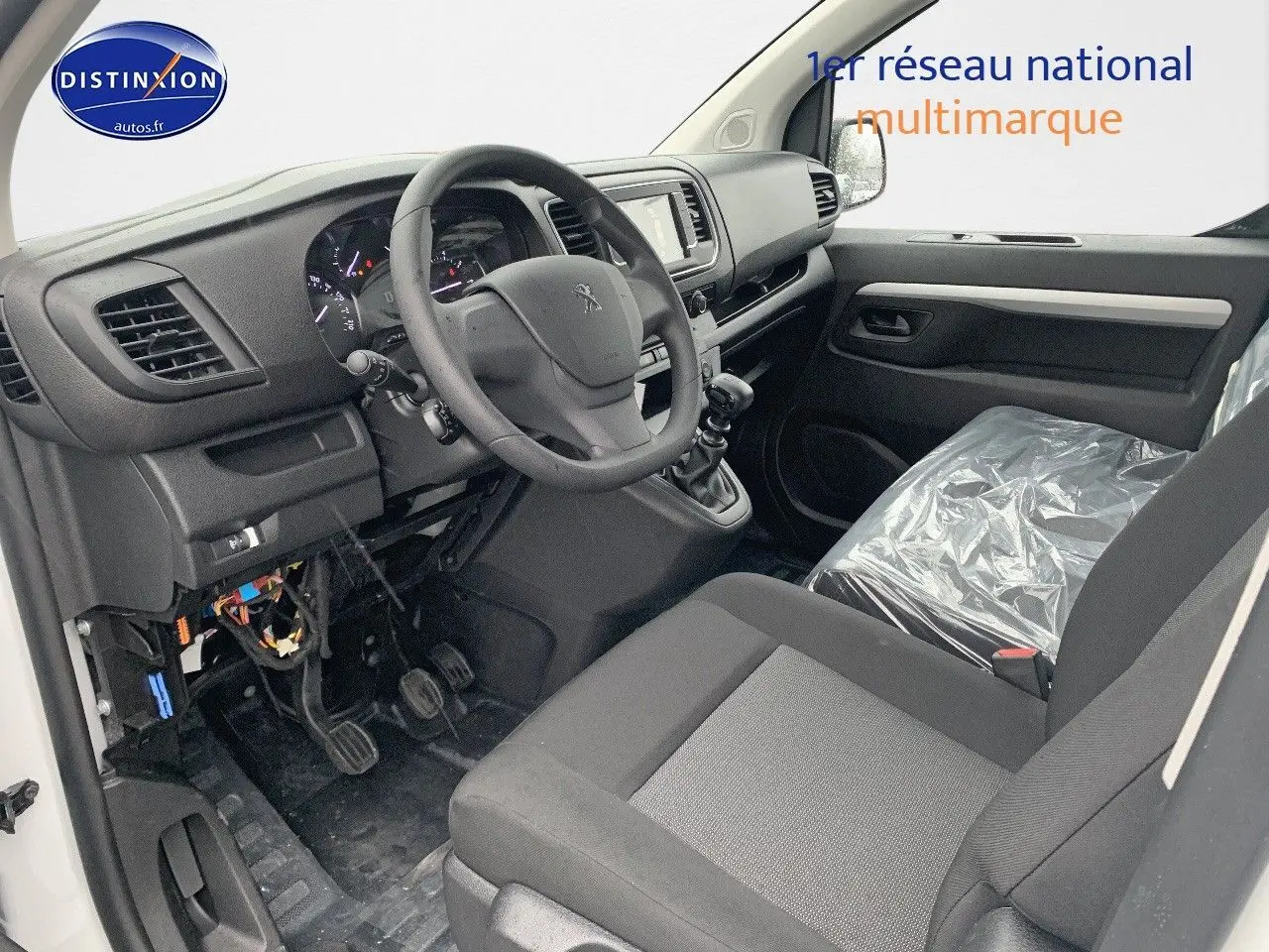 Intérieur avant droit du Peugeot Expert Long 2023, sièges gris, volant multifonction et tableau de bord moderne.