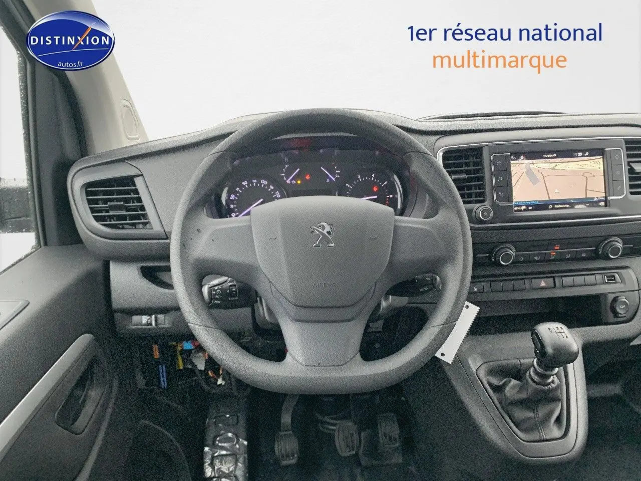 Vue intérieure frontale du tableau de bord et volant du Peugeot Expert Long blanc avec boîte manuelle et écran de navigation intégré.