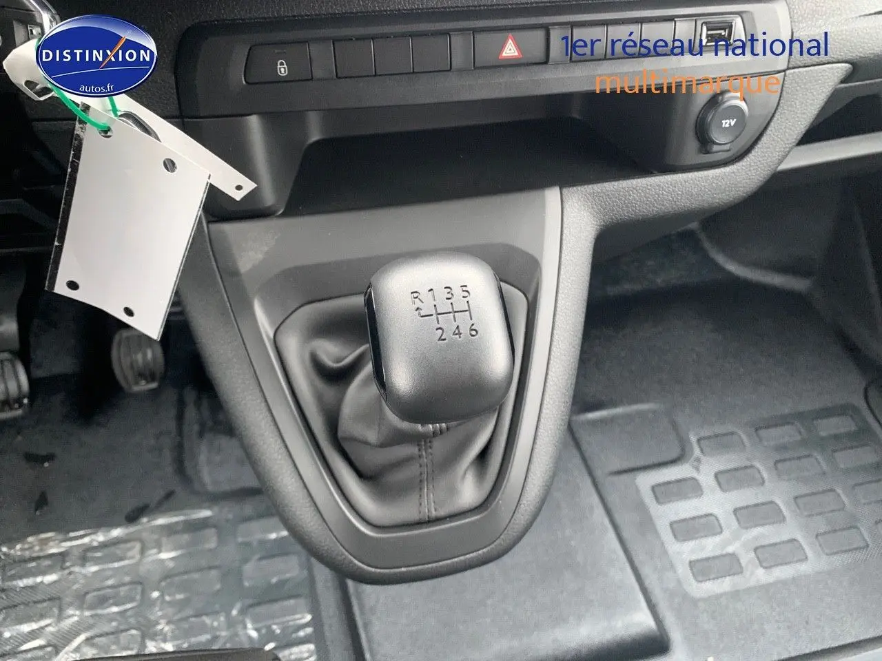 Le levier de vitesses manuel 6 rapports du Peugeot Expert Long 2023, avec console grise et tapis noirs.