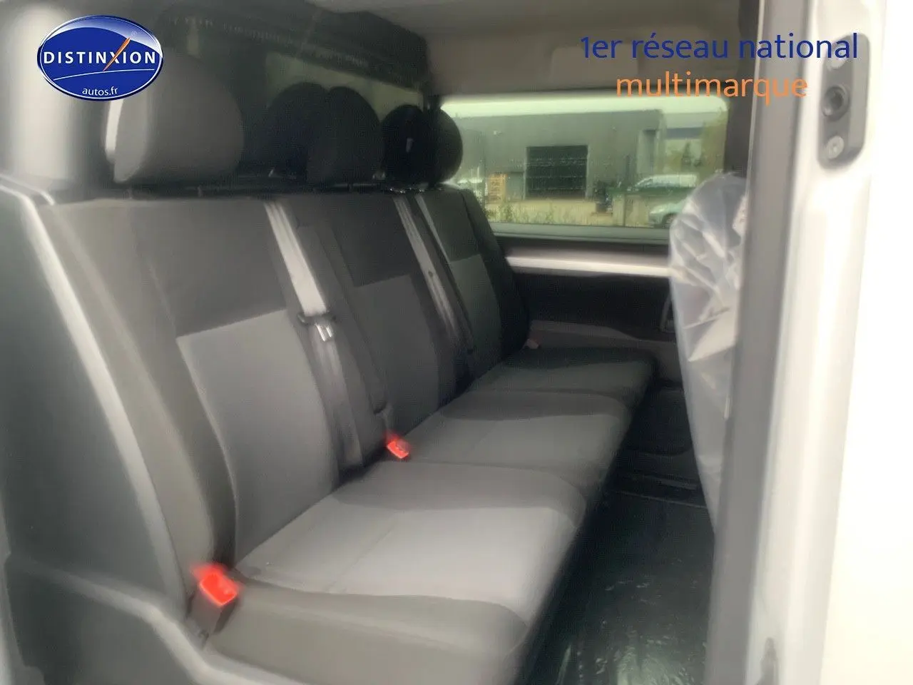 Vue latérale intérieure du Peugeot Expert Long 2023 montrant la banquette arrière en tissu gris et noir.