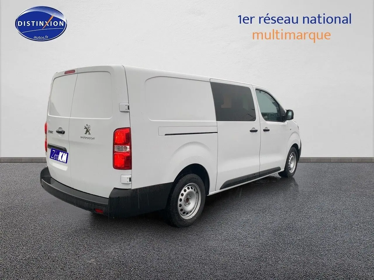 Vue 3/4 arrière droite d'un Peugeot Expert blanc 2023, fourgon long avec vitres teintées et jantes acier simples.