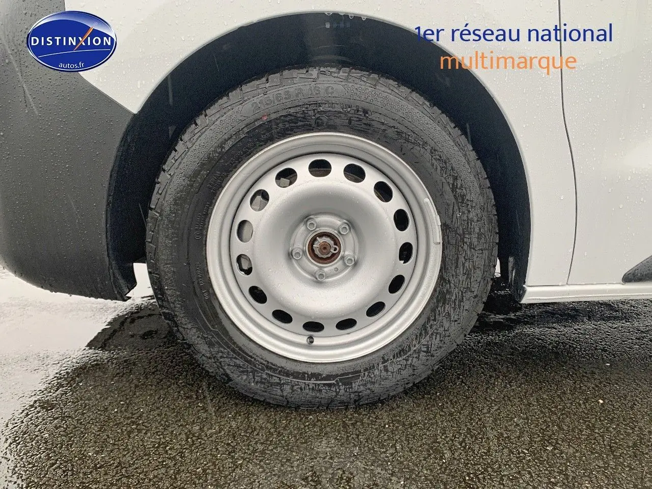 Gros plan sur la roue arrière droite en acier d'un Peugeot Expert Cabine Approfondie blanc sous la pluie.
