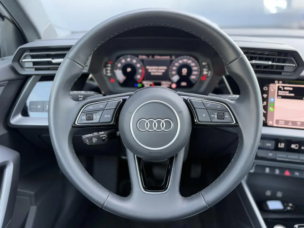 Volant cuir 3 branches multifonctions de l'Audi A3 Sportback 2024 avec tableau de bord numérique et écran central visible