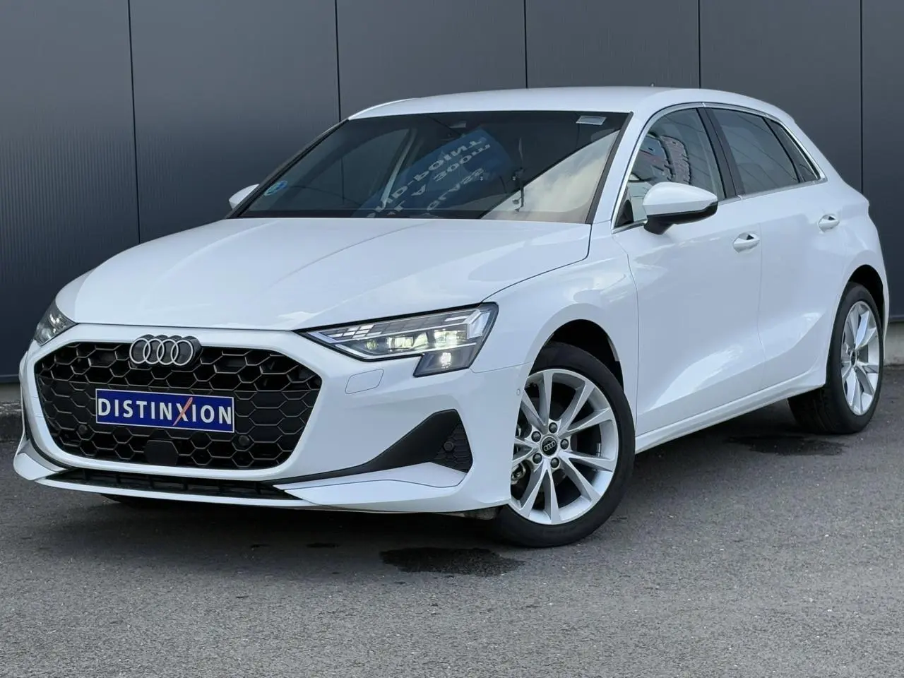Audi A3 Sportback blanc Arkona vue 3/4 avant droit avec calandre noire et jantes alliage 17 pouces.