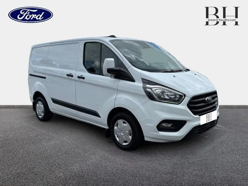 Fourgon Ford Transit Custom blanc Glacier vu en 3/4 avant droit avec calandre noire et jantes acier.