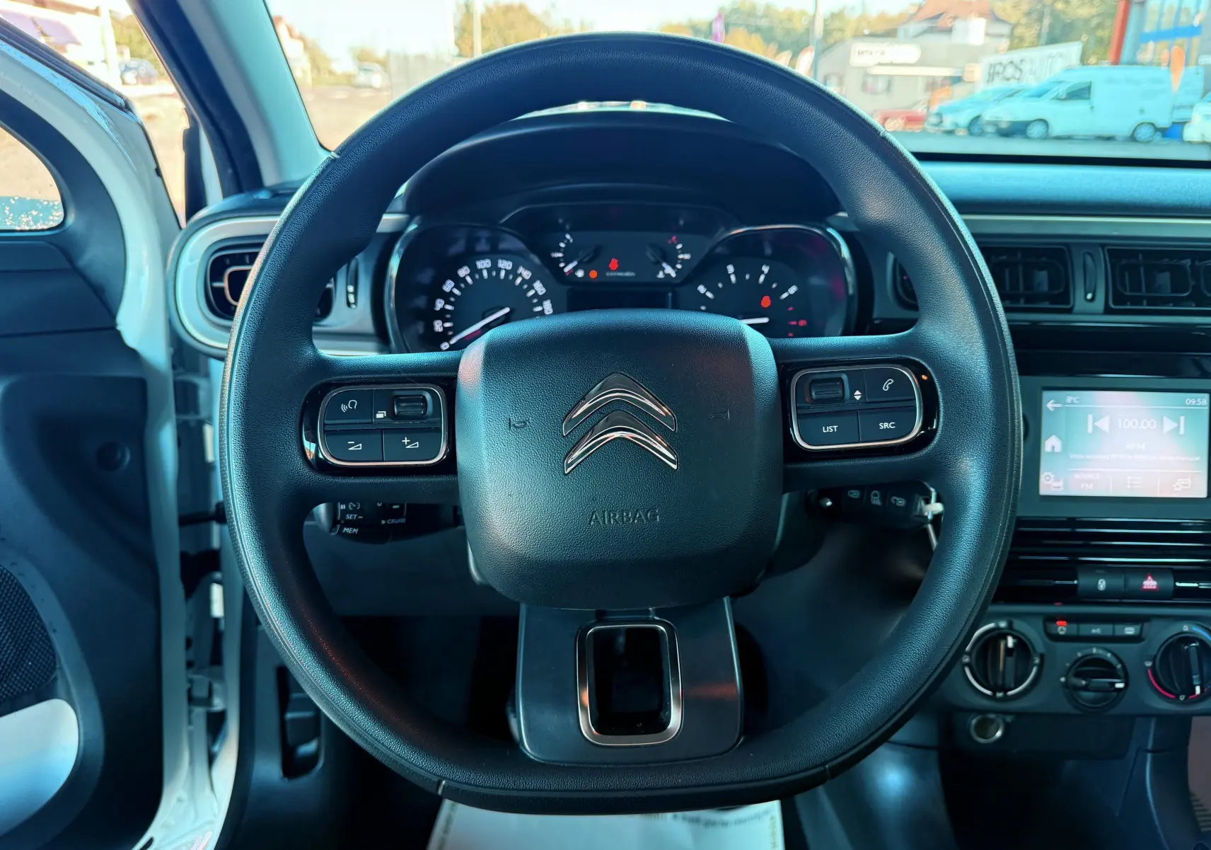 Vue centrée sur le volant noir de la Citroën C3 blanche 2021 avec tableau de bord et écran tactile visible
