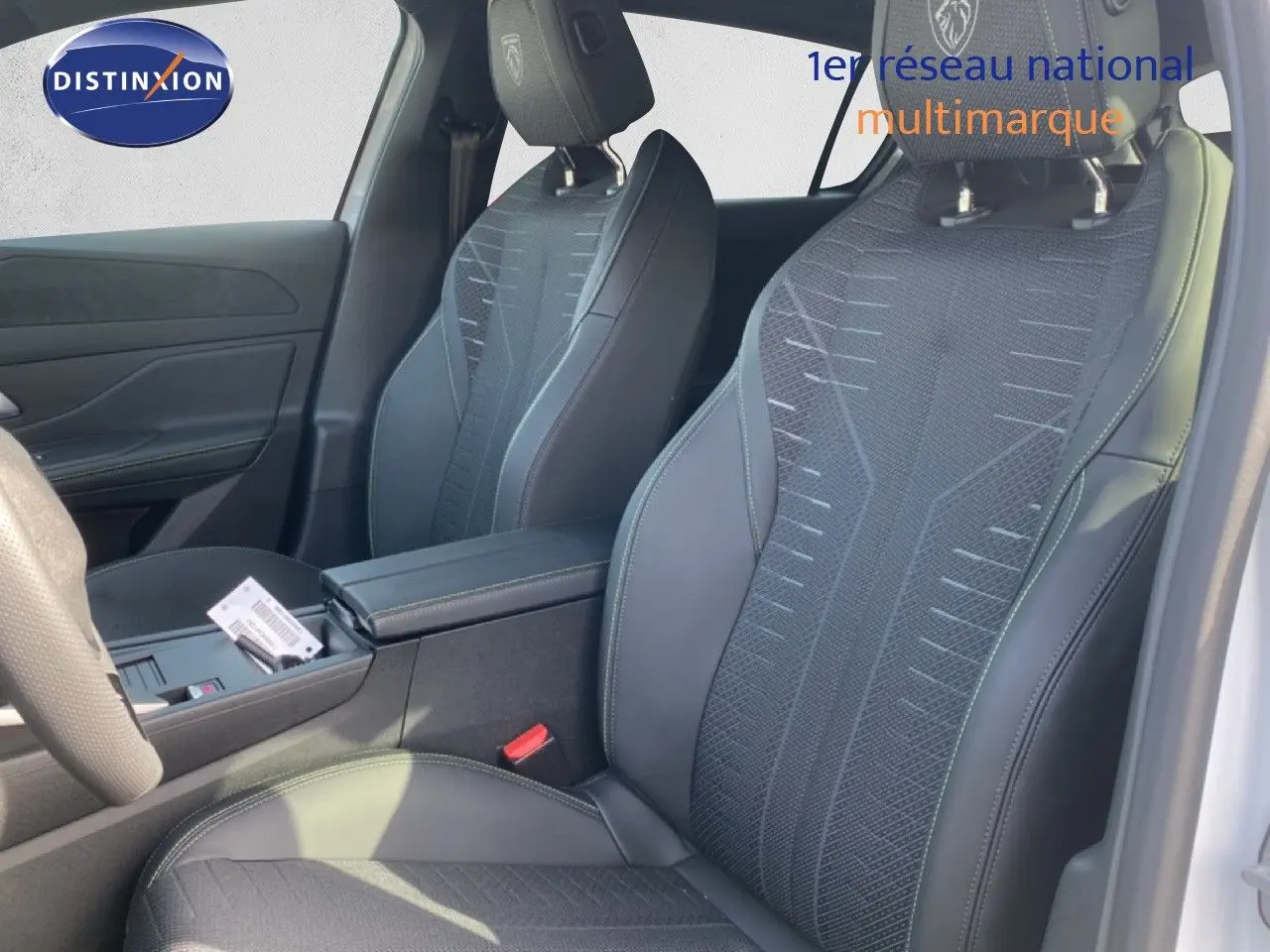 Vue intérieure côté droit des sièges avant en tissu et cuir noir avec logo Peugeot sur les appuie-têtes.