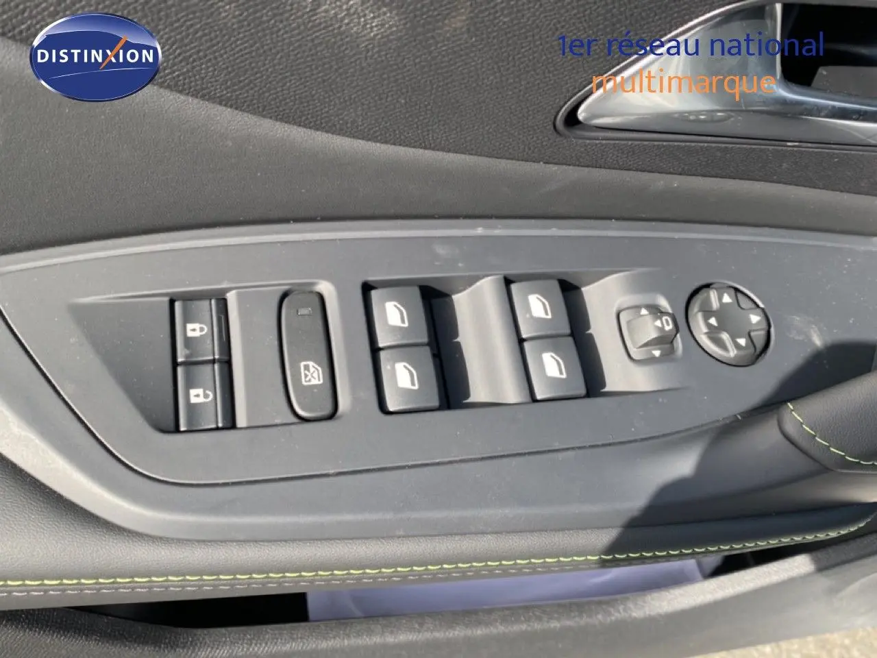 Gros plan sur les commandes de lève-vitres et rétroviseurs côté conducteur d’un Peugeot 308 Hybrid blanc, intérieur noir.