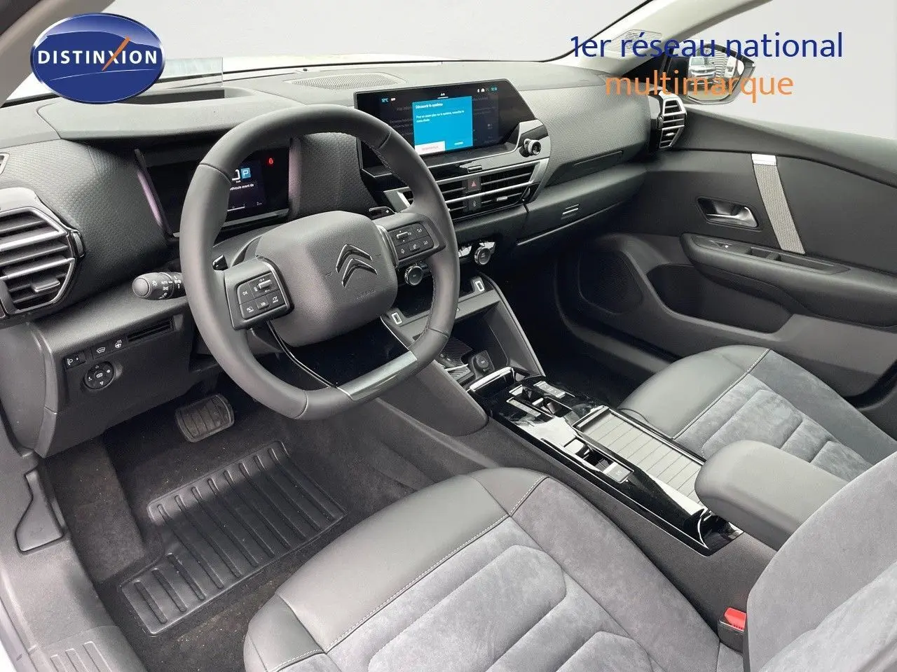 Intérieur avant droit de la Citroën C4 2024, sièges cuir noir et alcantara gris, tableau de bord moderne avec écran tactile.