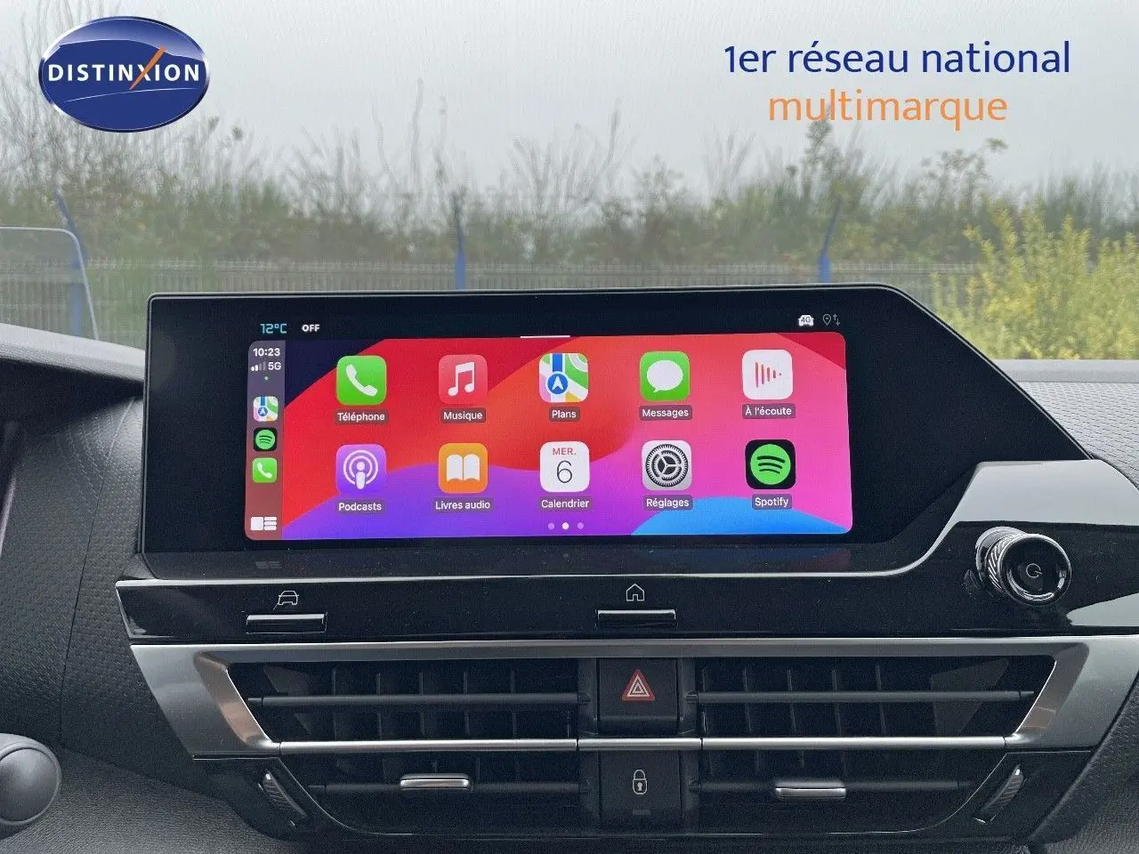 Écran tactile central du tableau de bord de la Citroën C4 2024 blanc métal affichant les applications Apple CarPlay.