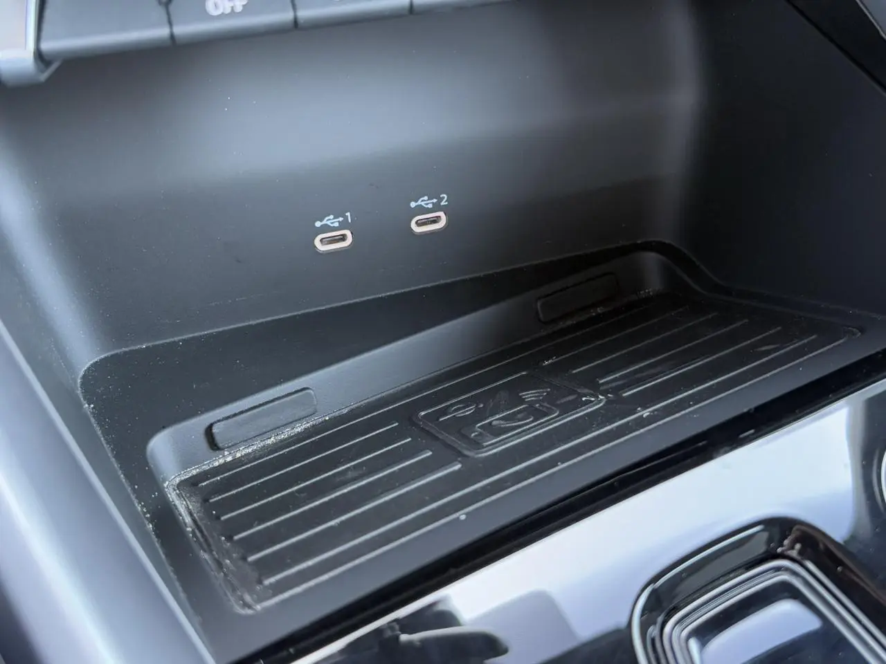 Vue rapprochée de la console centrale noire de l'Audi A3 Sportback 2024 montrant deux ports USB-C et un espace de recharge sans fil.