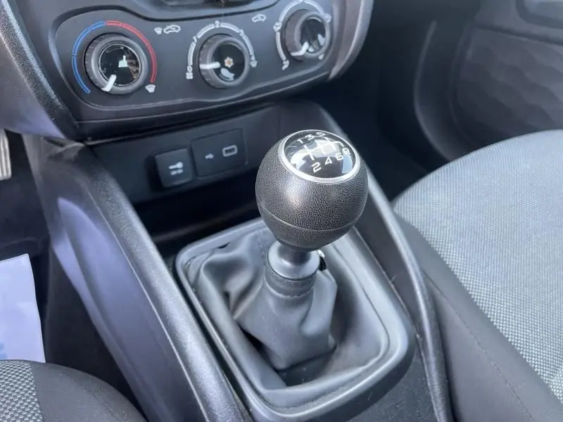 Le levier de vitesses manuel noir de la Fiat Tipo 1.4 Street 2019, vu en gros plan depuis l'intérieur côté conducteur.