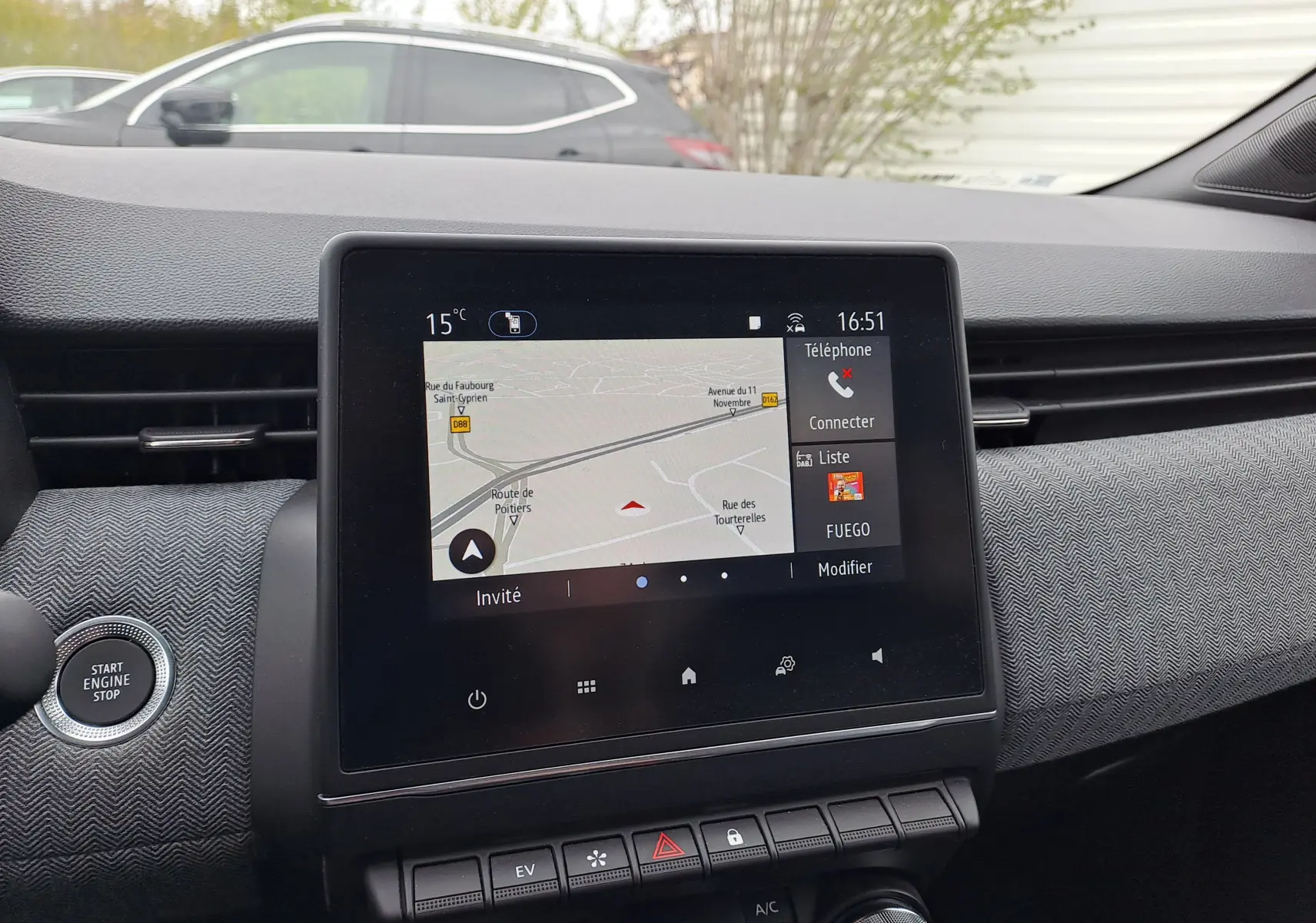 Vue intérieure centrée sur l'écran tactile du tableau de bord de la Renault Clio V hybride, avec bouton Start/Stop visible.