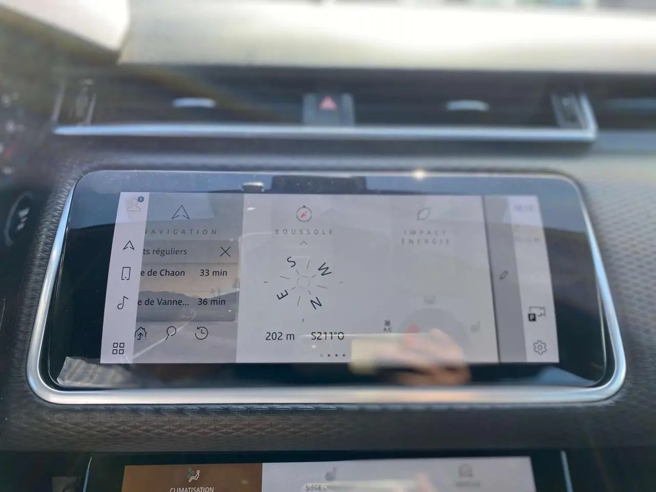 Écran tactile central du Range Rover Velar 2022 affichant navigation et boussole, avec tableau de bord noir texturé.