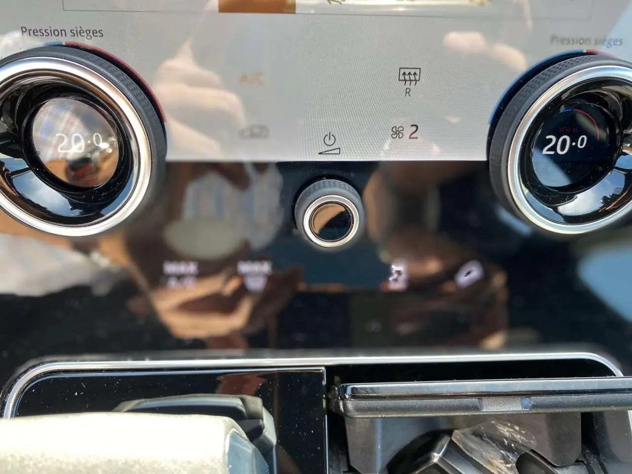 Détail du tableau de bord du Range Rover Velar 2022 montrant les commandes de climatisation et les aérateurs ronds chromés.