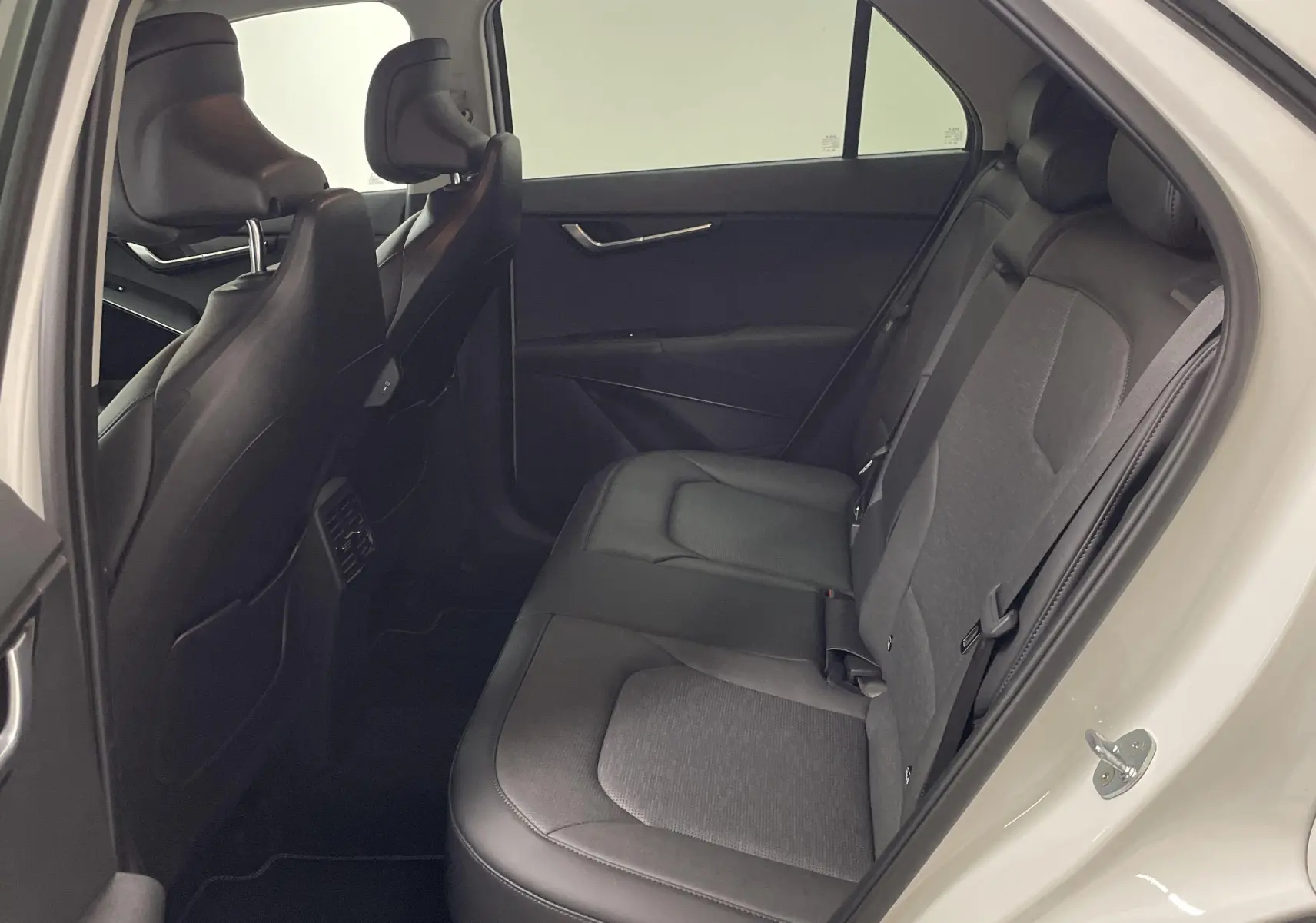 Vue intérieure côté droit sur les sièges arrière en cuir et tissu du KIA NIRO blanc 2025 hybride essence.
