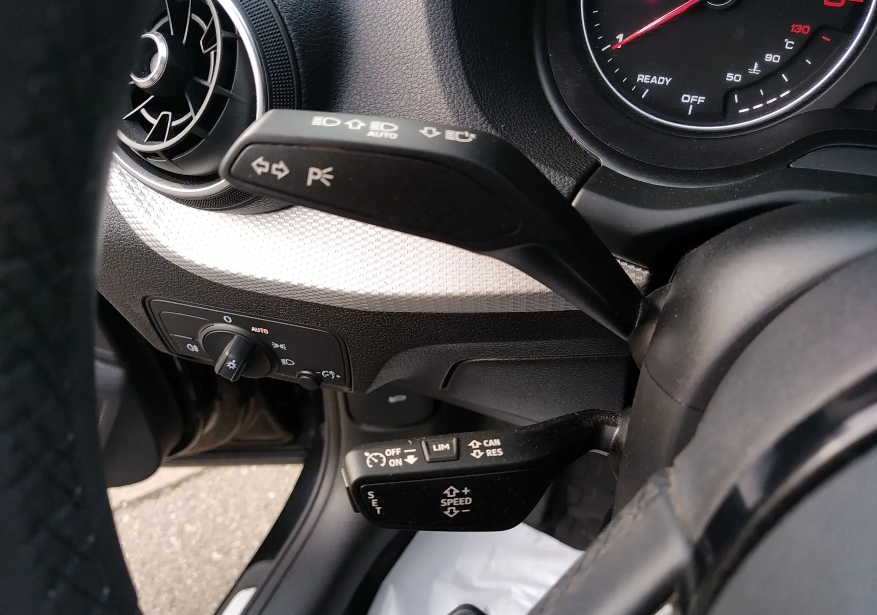 Gros plan sur les commandes au volant et le tableau de bord de l'Audi Q2 35 TFSI S-Line 2023 en tissu gris.