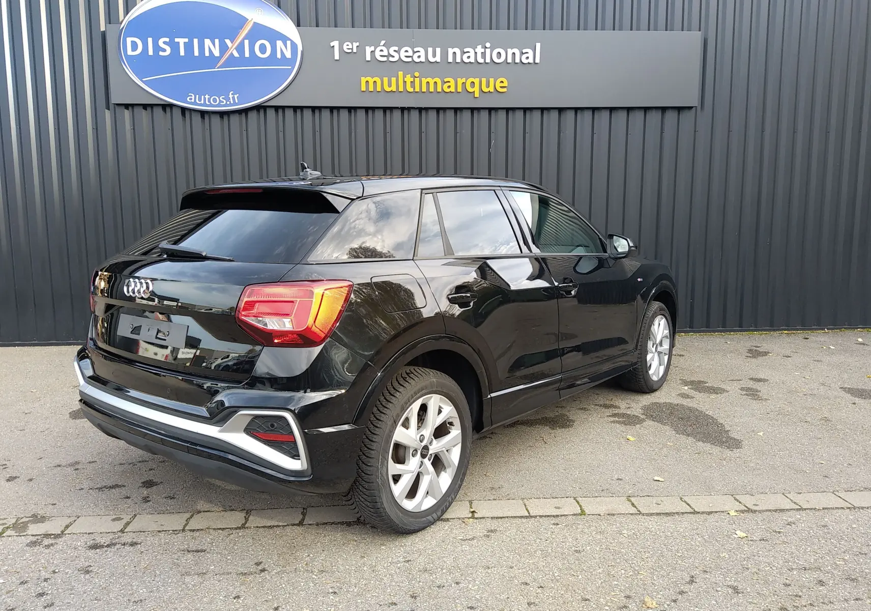 Audi Q2 noir mito metal en 3/4 arrière droit, mettant en valeur ses feux LED et jantes alliage 17 pouces.
