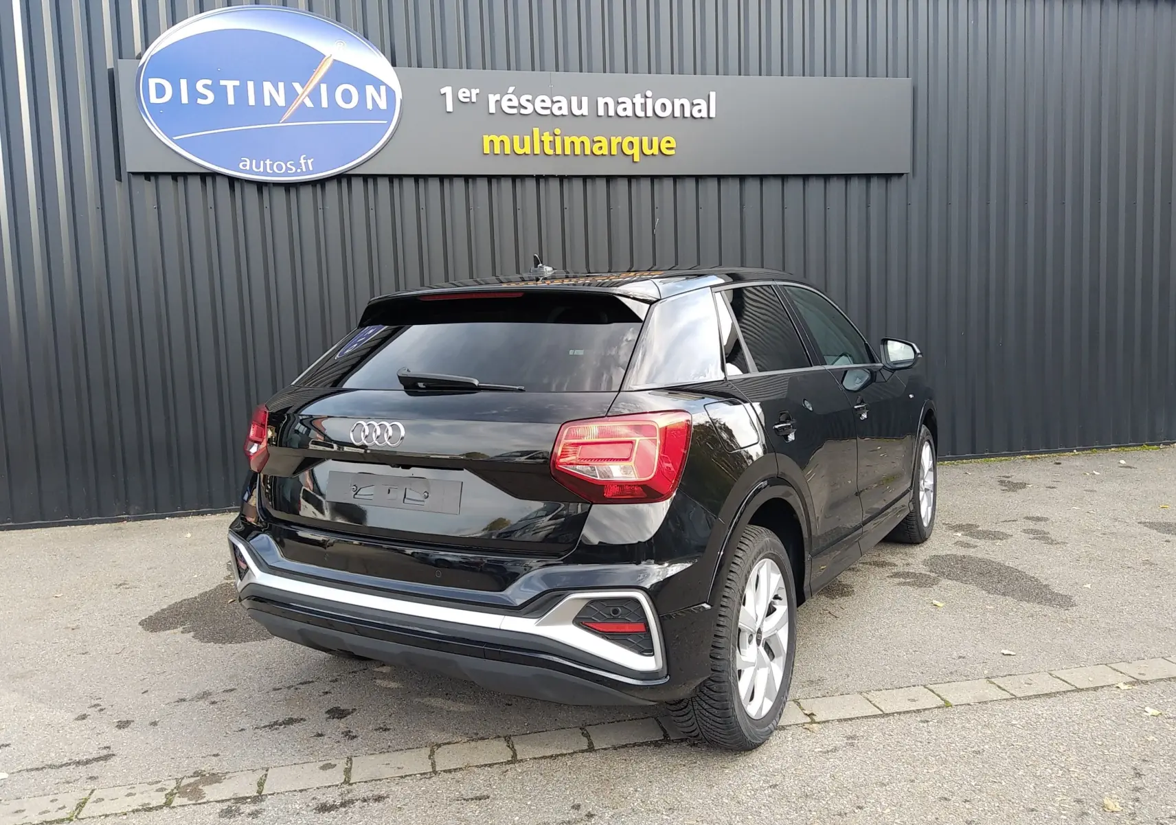 Audi Q2 noir mito metal vue 3/4 arrière droit, avec feux arrière LED et jantes alliage argentées.