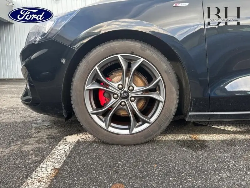 Gros plan sur la roue avant gauche d'une Ford Focus noire Shadow avec étrier de frein rouge et jante alu ST-Line.