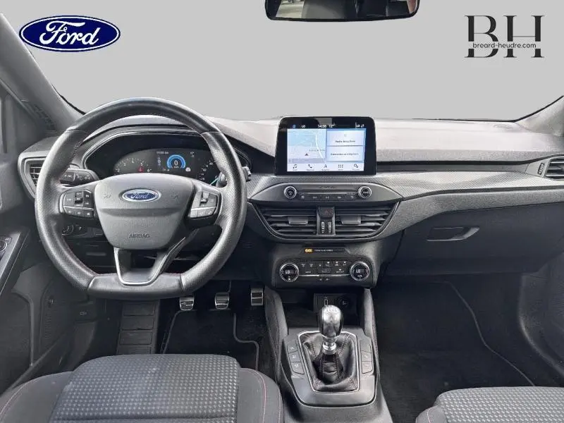 Vue intérieure avant de la Ford Focus 1.0 EcoBoost 2019 avec volant cuir multifonction et écran tactile central.