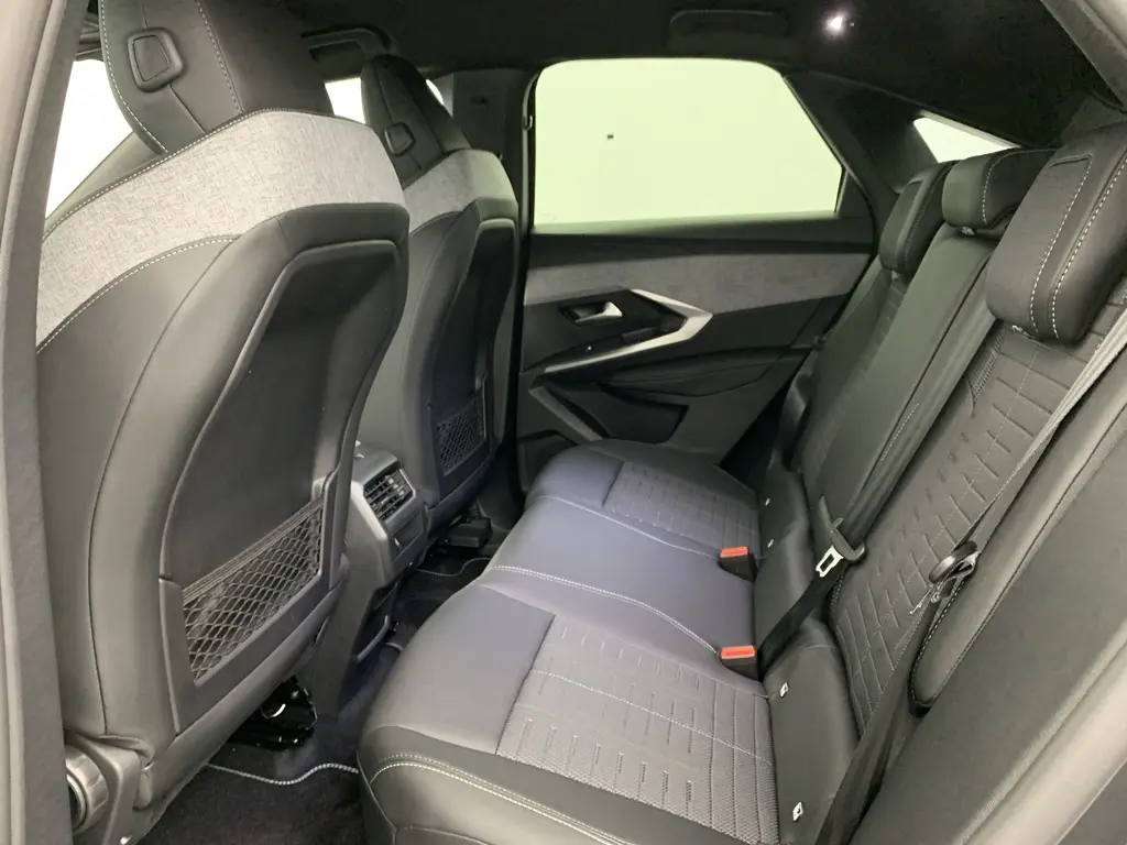 Vue intérieure côté droit des sièges arrière en tissu et cuir noir avec surpiqûres blanches du Peugeot 3008 Hybrid 2025.
