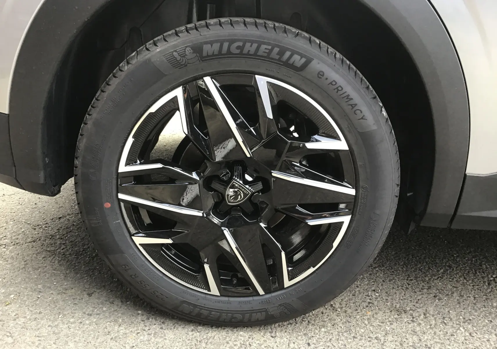Gros plan sur la roue avant droite du Peugeot 3008 gris Artense, jante alliage noire et argentée de 19 pouces.