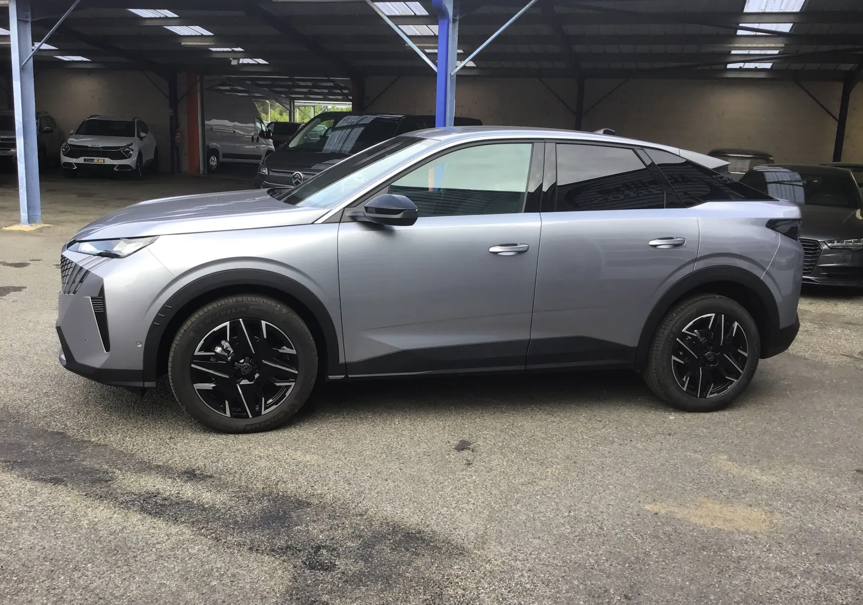 Peugeot 3008 1.2 HYBRID 145 en gris Artense, vue de profil côté gauche, jantes noires distinctives.