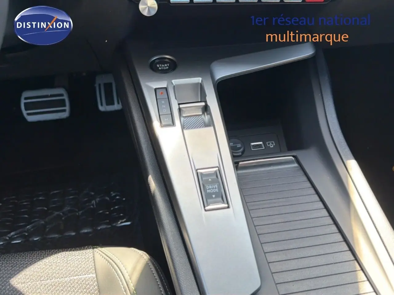 Vue rapprochée de la console centrale de la Peugeot 308 Hybrid 145ch GT, avec levier de vitesses et commandes argentées.