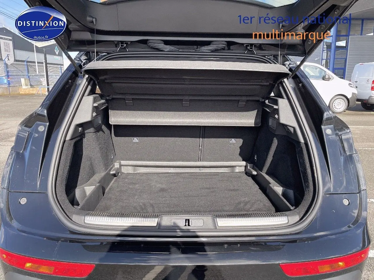 Coffre ouvert d'un DS7 Crossback E-TENSE noir perle métal, vue arrière montrant l'espace de chargement vide.