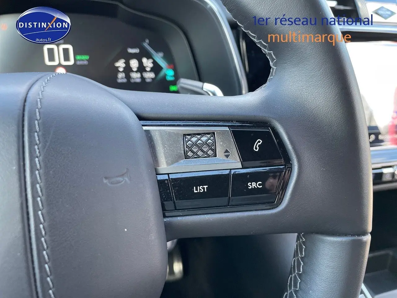 Gros plan sur les commandes gauche du volant en cuir noir du DS7 Crossback E-TENSE 2021, affichage numérique en arrière-plan.