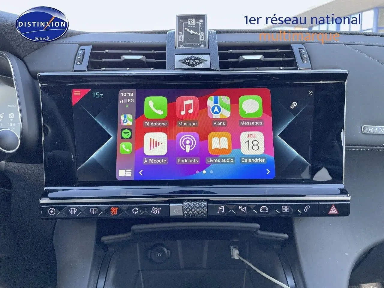 Écran tactile central du DS7 Crossback noir perle, affichant les applications Apple CarPlay, avec horloge analogique au-dessus.