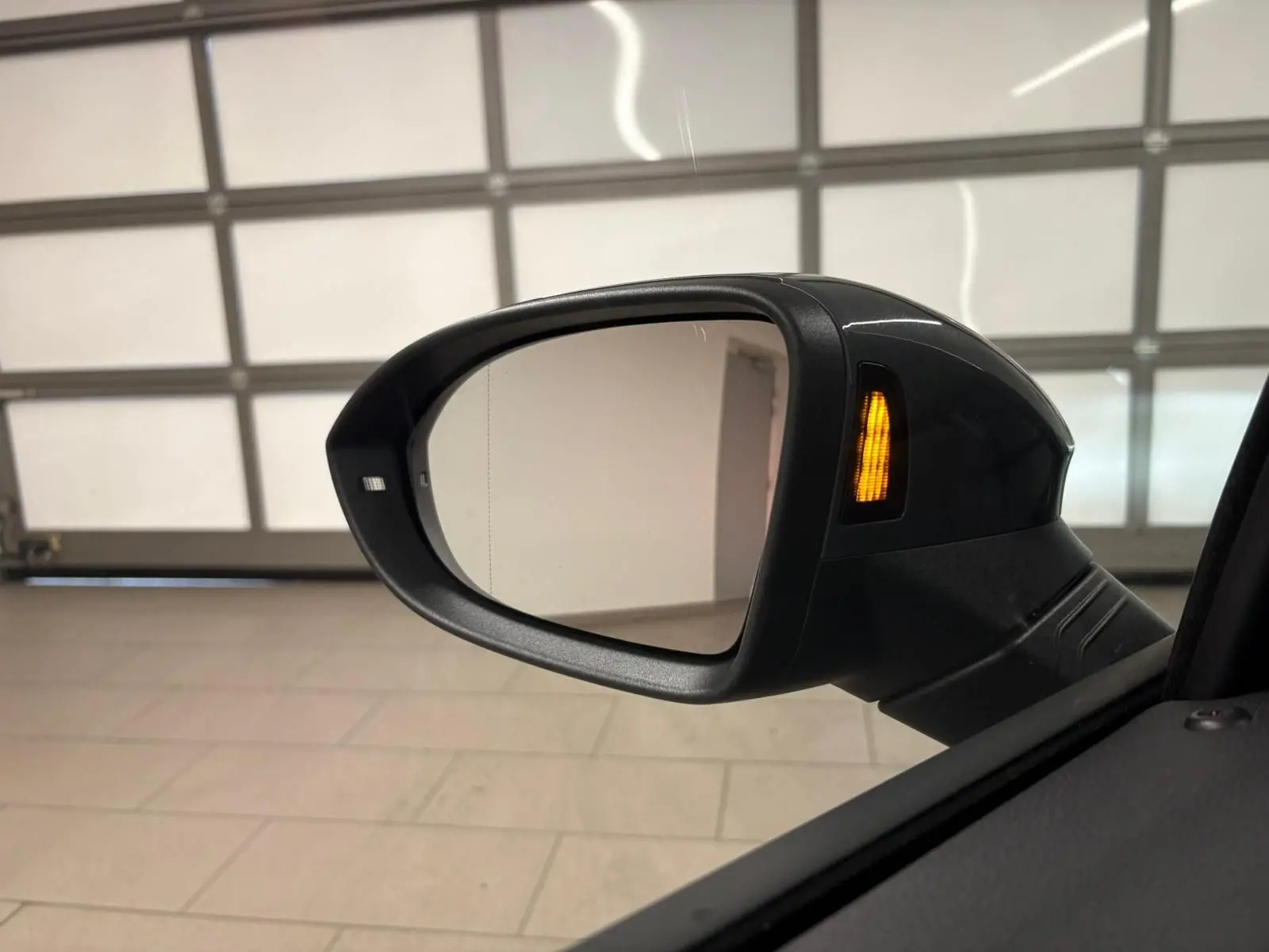 Rétroviseur extérieur droit gris dauphin de Volkswagen Golf 1.5 eTSI 150 R-Line avec clignotant allumé.