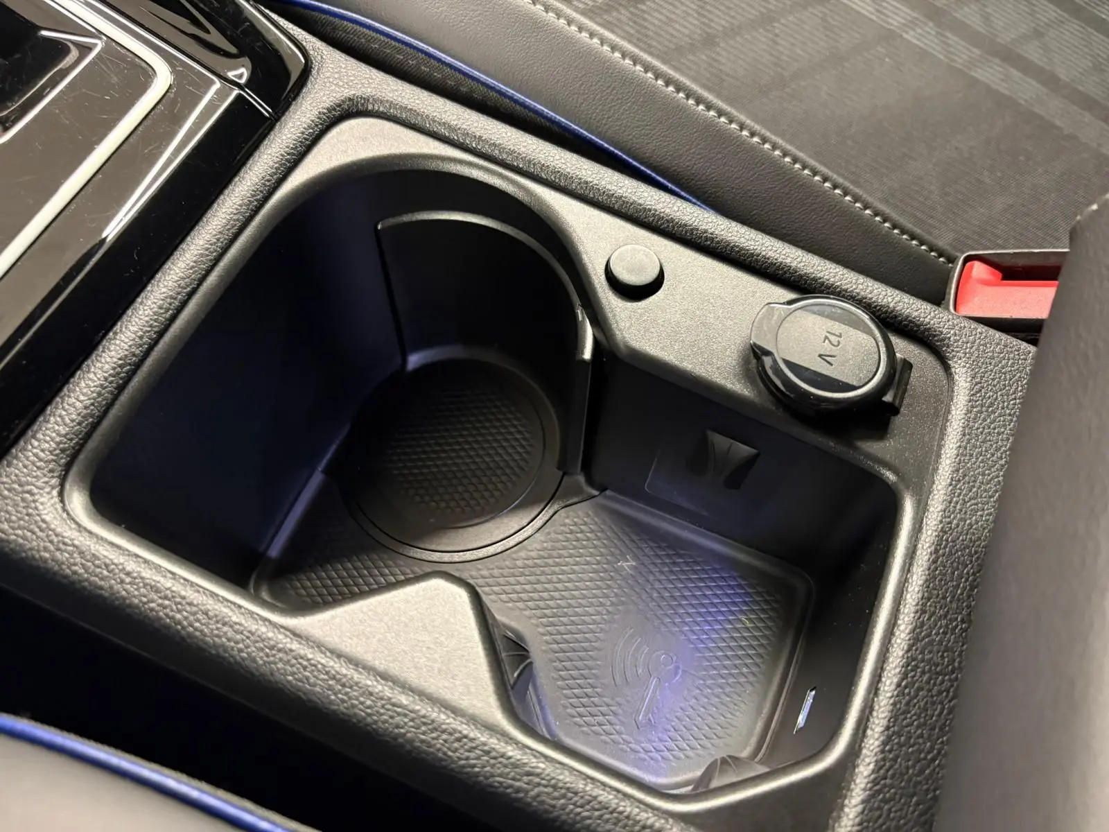 Gros plan sur la console centrale de la Volkswagen Golf 1.5 eTSI R-Line 2025, montrant un espace porte-gobelet et prise 12V.