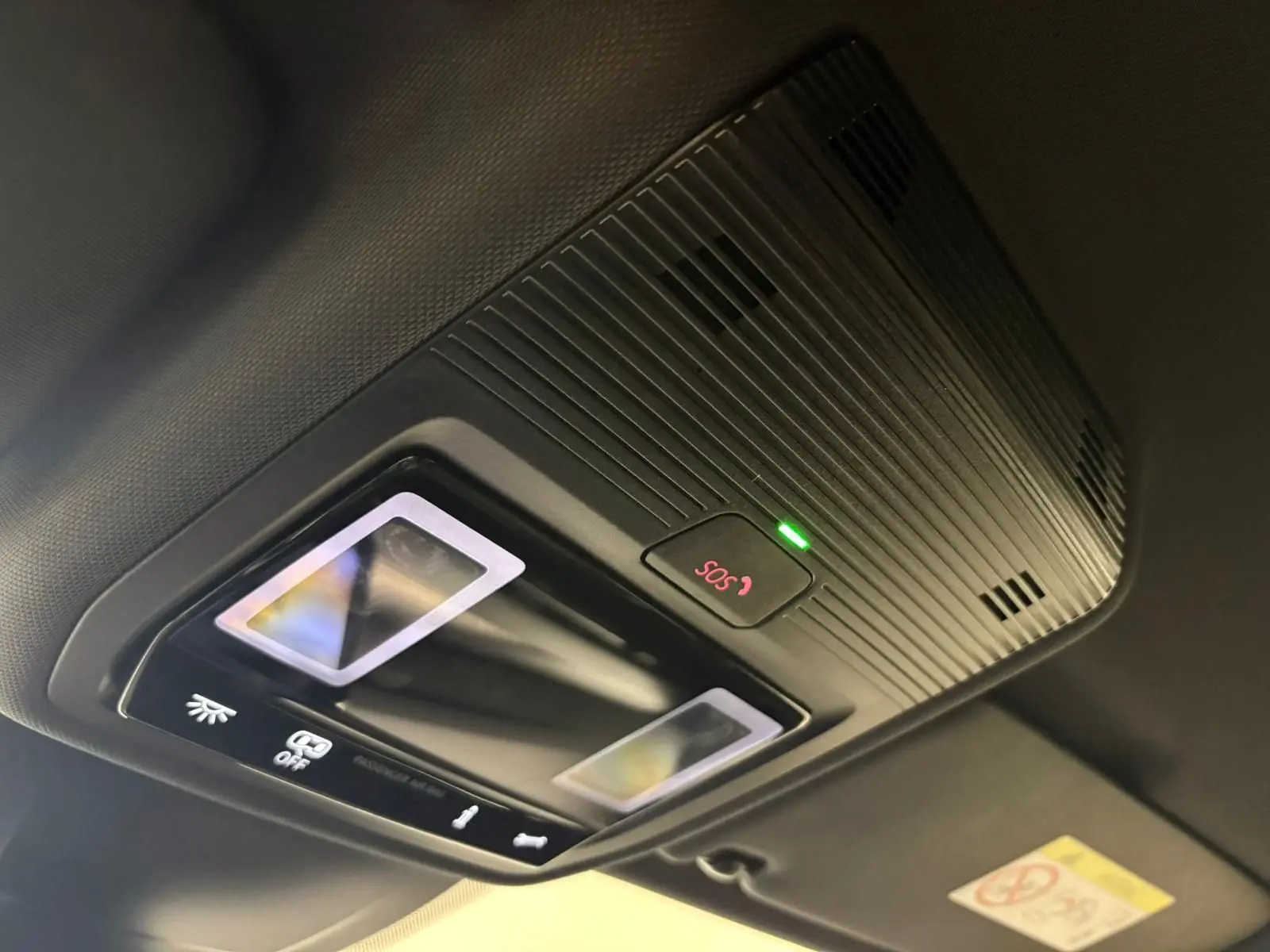 Gros plan sur le plafonnier intérieur avec bouton SOS illuminé en rouge dans une Volkswagen Golf Gris Dauphin 2025.