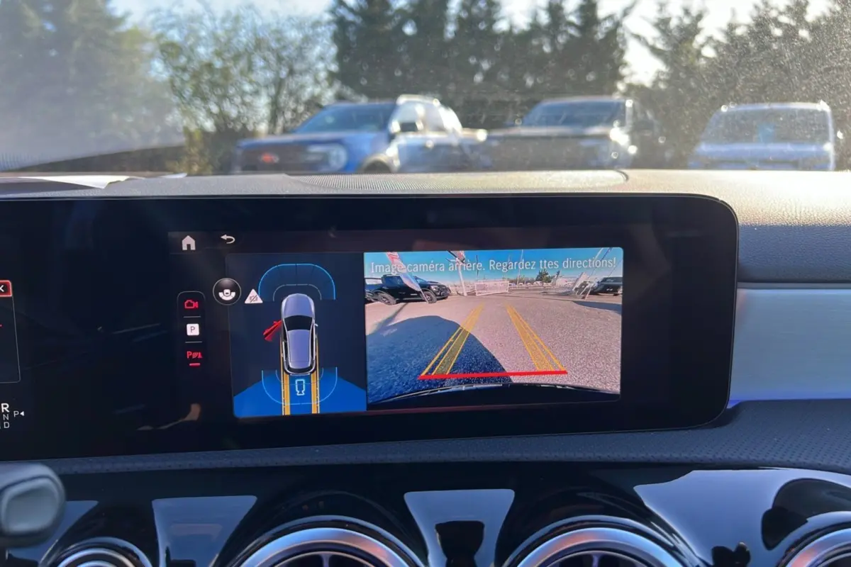 Écran central de la Mercedes Classe A 200D BVA Exclusive Design noir cosmos montrant la caméra de recul et l’aide au stationnement.