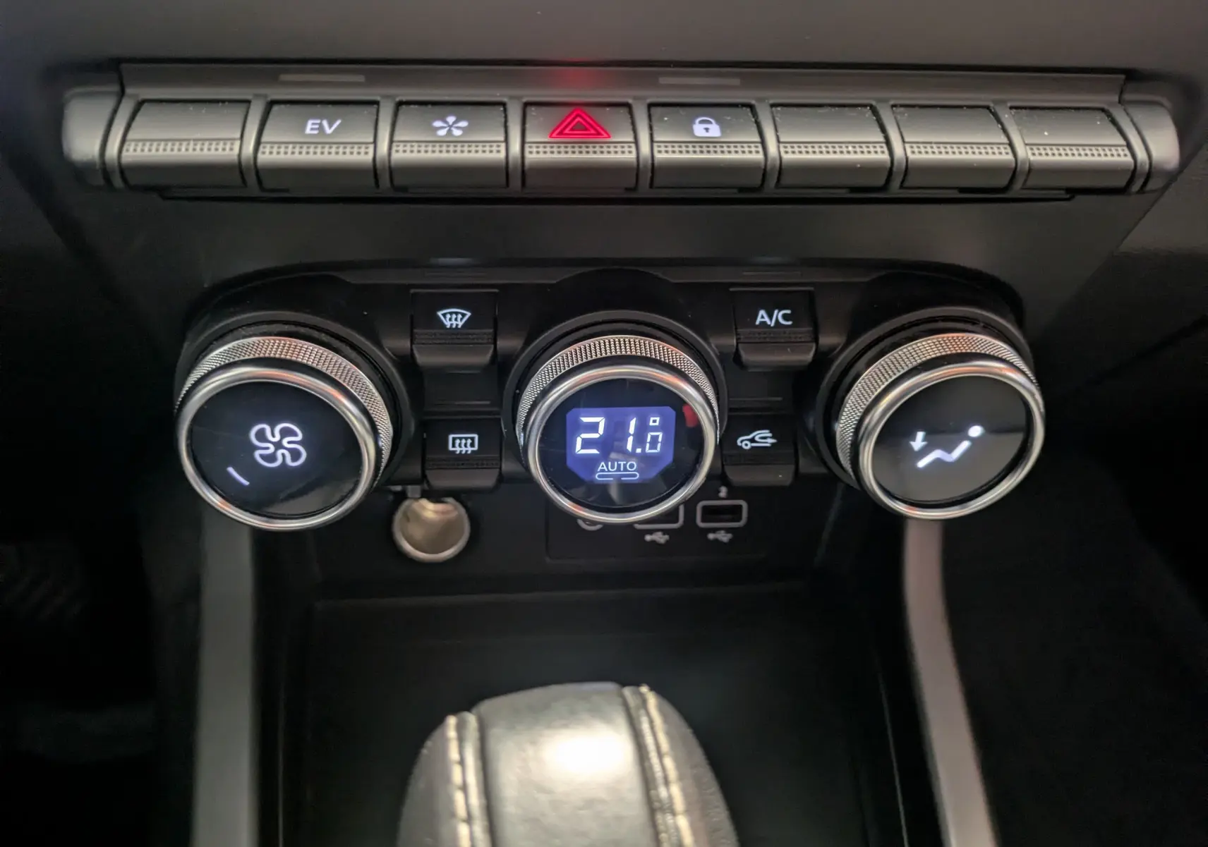 Gros plan sur les commandes de climatisation du tableau de bord du Renault Arkana noir, avec affichage digital à 21°C.