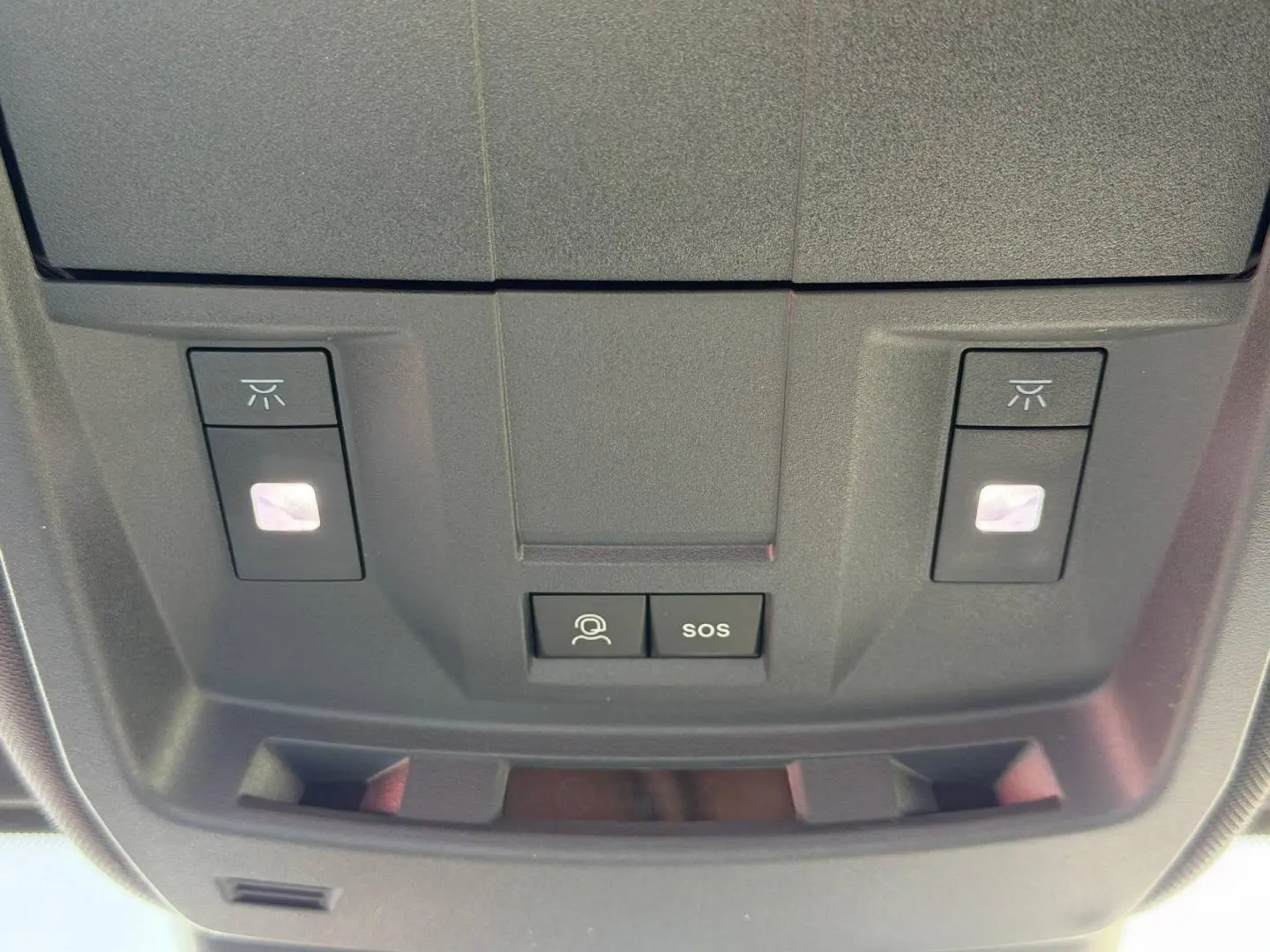 Vue en gros plan du plafonnier noir avec boutons d'éclairage et commandes SOS du Peugeot 3008 Hybrid 2026.