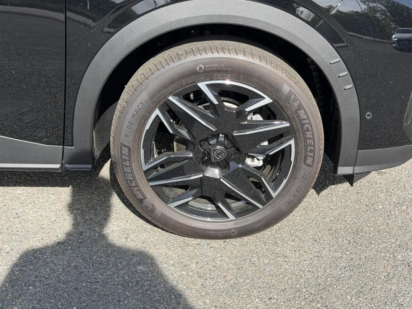 Gros plan sur la roue avant droite noire avec jante alu au design moderne du Peugeot 3008 noir Perla Nera.