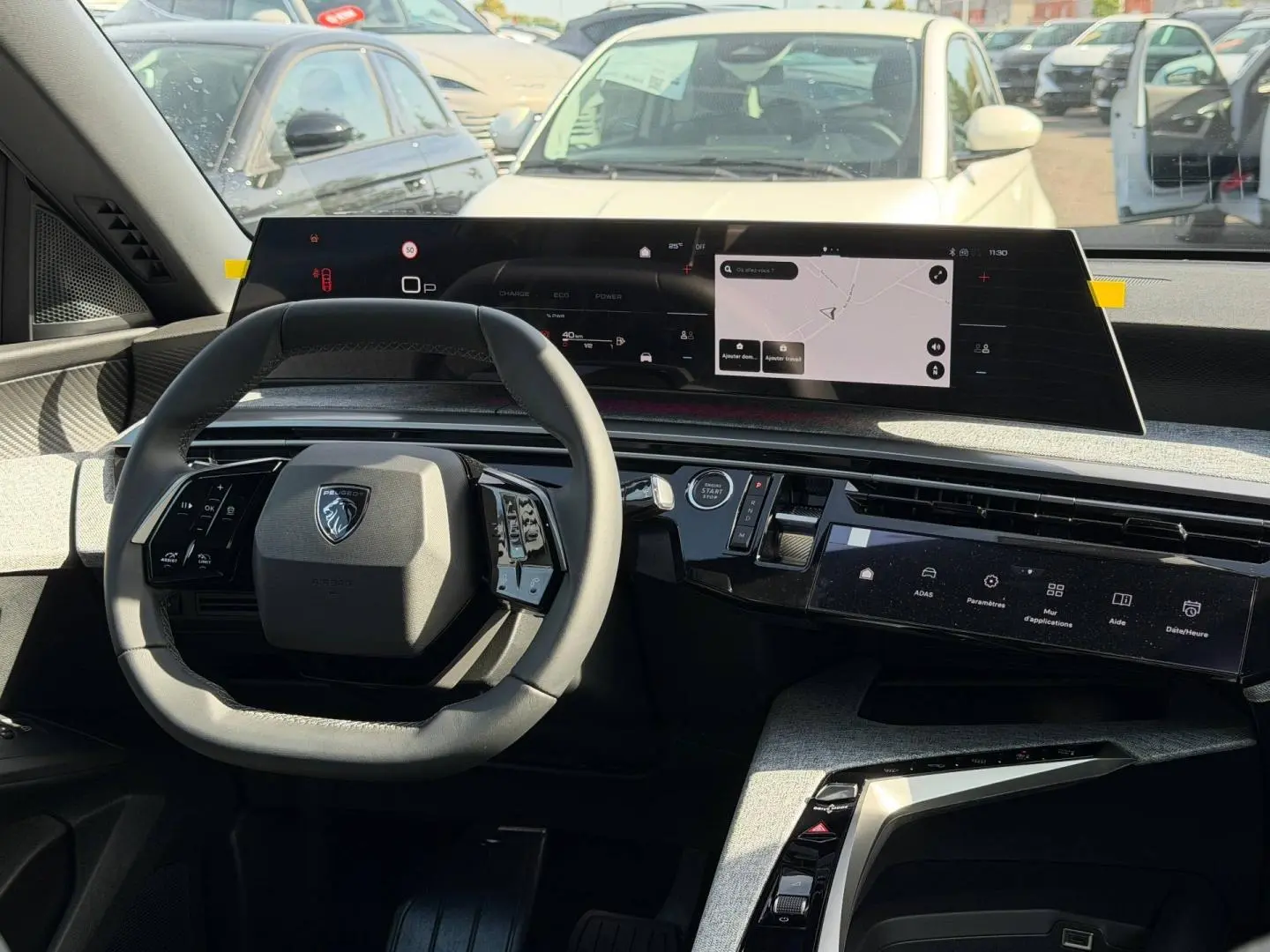 Intérieur du Peugeot 3008 hybride 2026 vu de face, volant cuir et double écran tactile moderne.