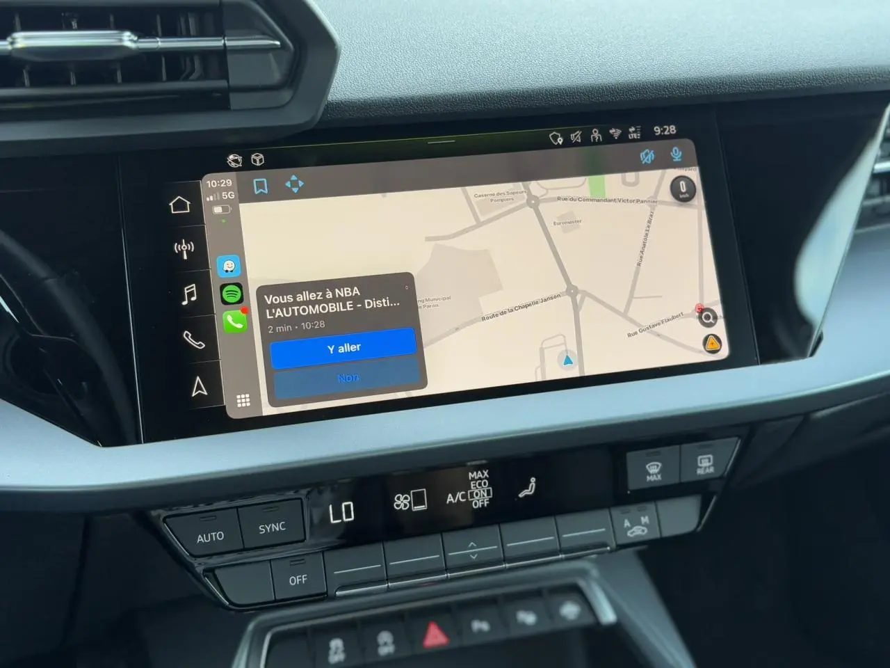 Écran tactile central de l'Audi A3 Sportback 2024 affichant la navigation Apple Car Play en intérieur noir et gris.