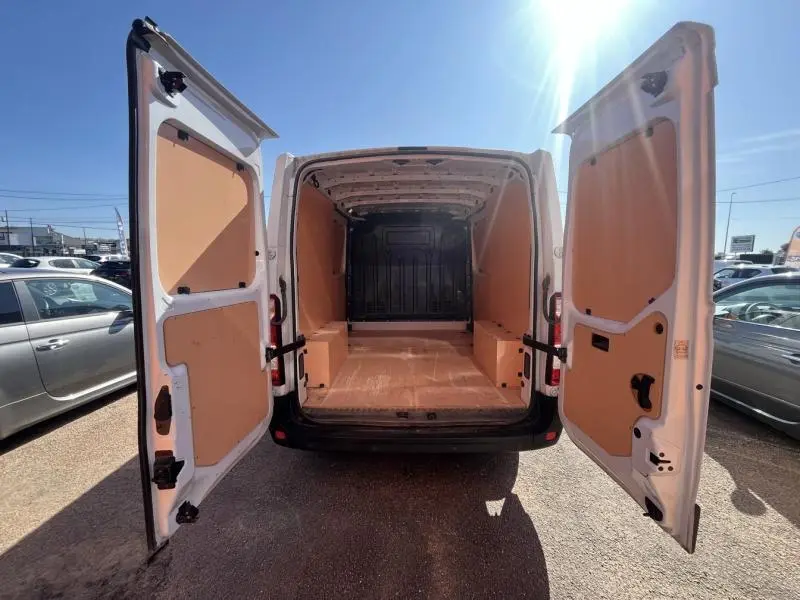 Vue arrière du Renault Master blanc glacier 2018 avec portes ouvertes montrant l'espace de chargement vide et cloison complète.